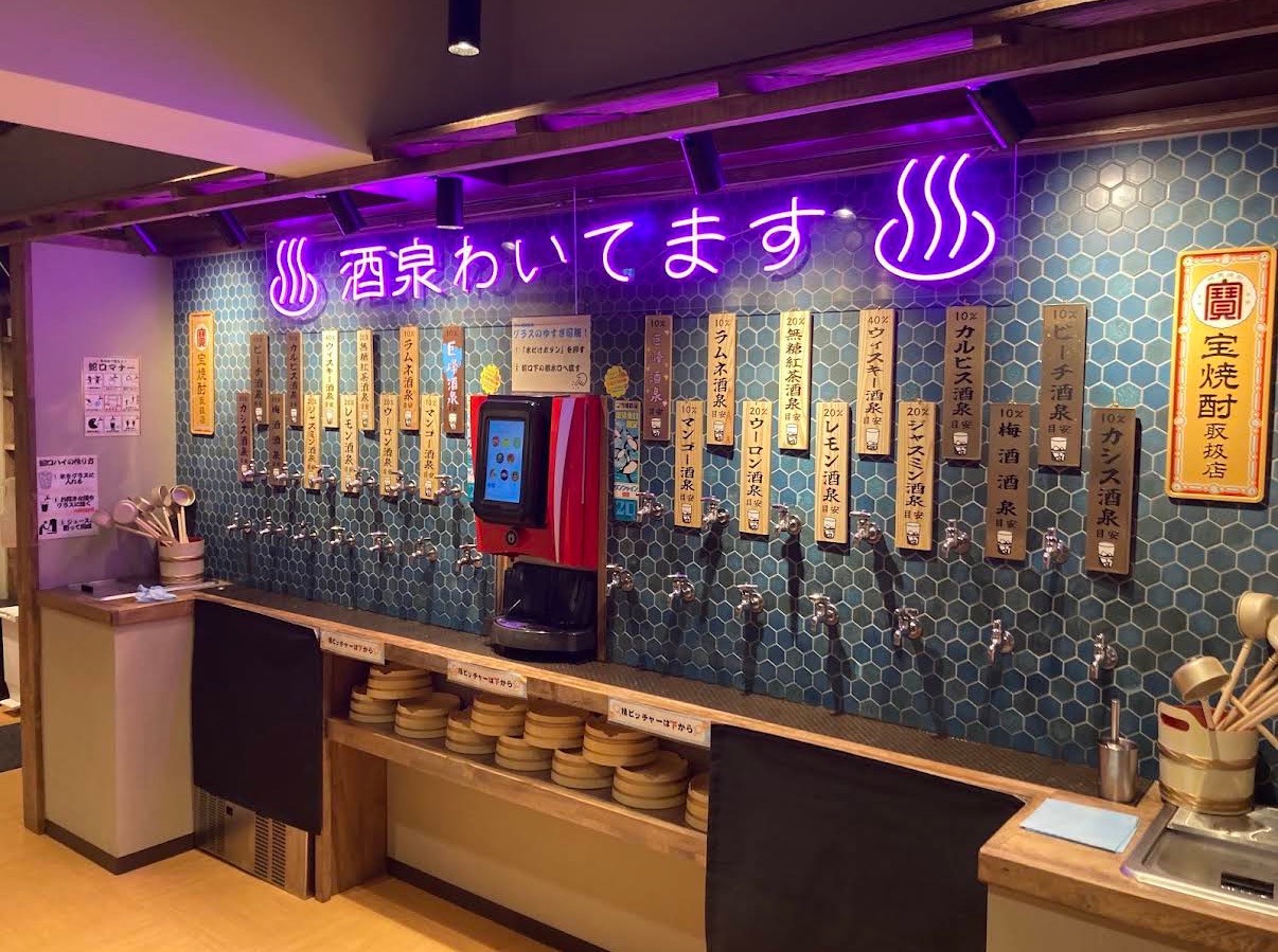 紫色のネオンと酒類サーバーが並ぶ店舗内観